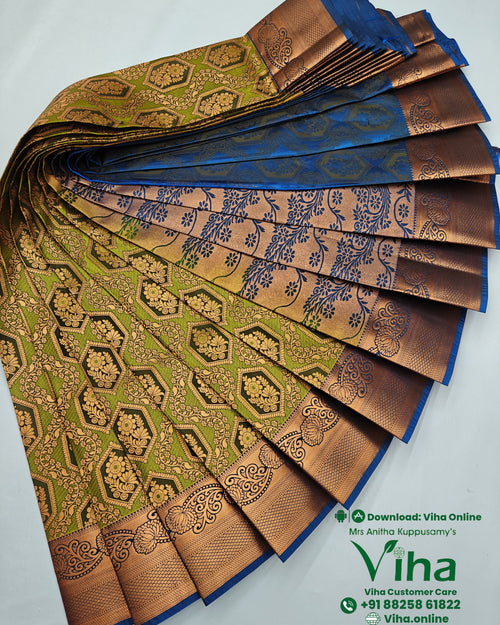 Silk Saree, an arrangement of folded green and blue textile with shiny metallic-toned patterned borders displaying floral and geometric motifs