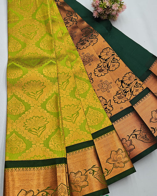 Silk Saree, a folded green textile featuring patterned gold-toned panels with floral motifs alongside a small pink floral ornament