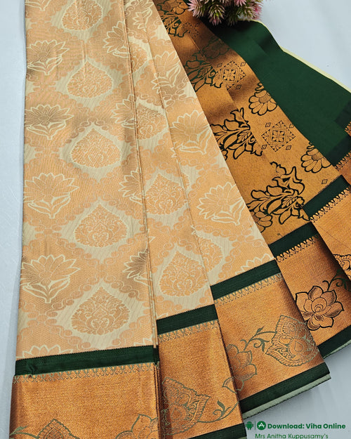 Silk Saree, folded cream and gold-toned fabric featuring repeating floral patterns, with dark green borders and one bunch of pink flowers at the top