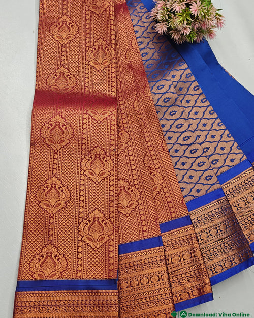 Silk Saree, a folded red and blue textile with gold-toned woven patterns, paired with a small bouquet of pink flowers