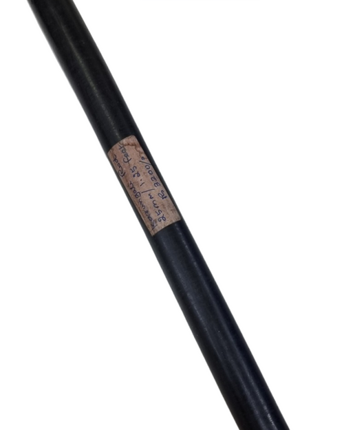 Ebony Wood Karungali Rod, a long smooth black rod with a handwritten paper label stuck in the middle