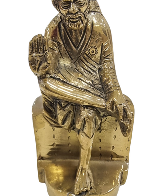Sai Baba in brass, seated figure with one leg crossed over the other on a rock-shaped base