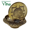 Varahi Amman Lamp, a gold-toned metallic round disc with geometric engraving, resting vertically in an ornate brass-toned bowl