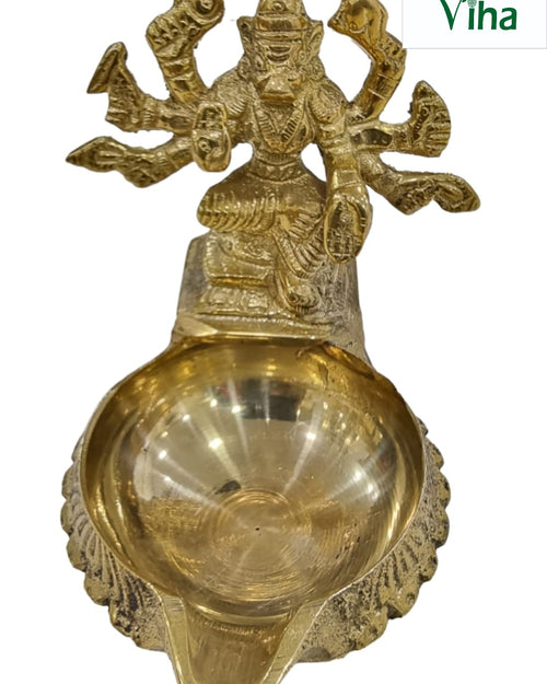 Varahi Amman lamp in brass, many-armed Varahi figure above a broad round oil bowl