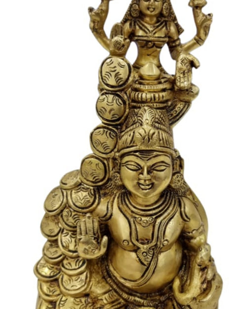 Lakshmi Kubera in brass, a smaller haloed figure standing above a seated pot-bellied figure with coins at the side