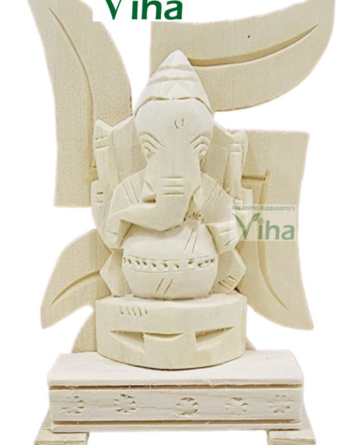 Vellerukku Vinayagar Swastik / Shwetark, off-white carved wooden figurine featuring a central figure over four leaf shapes and a rectangular base