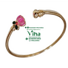 Impon Lotus Bracelet, a glossy gold-toned open bangle featuring one pink and green enameled lotus-shaped terminal and one ribbed terminal
