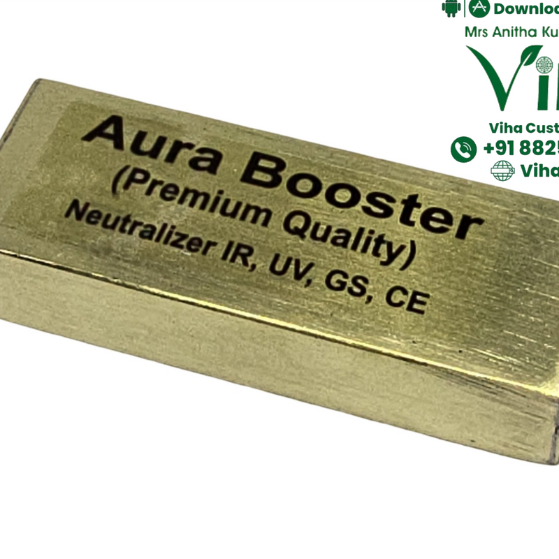 Aura Booster, a gold-toned rectangular block with black text printed on its top surface