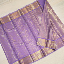 Designer Soft Silk Saree With Blouse, a folded purple fabric with glossy finish featuring metallic gold-toned floral and geometric patterns