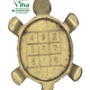 Vastu Tortoise Yantra - Brass, a gold-toned turtle-shaped object with a 3x3 numbered grid on its flat underside