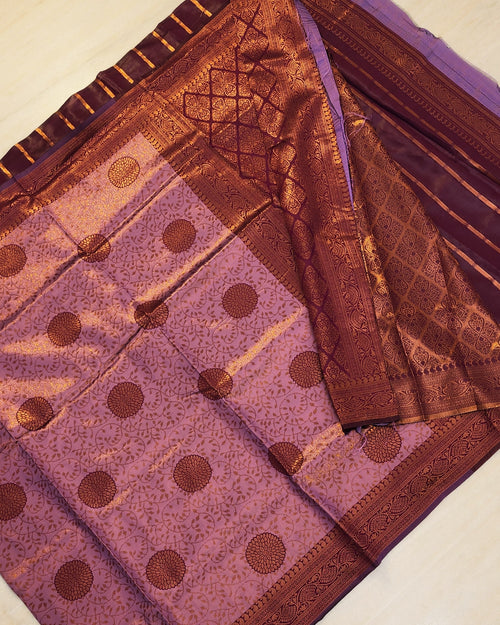 Soft Silk Saree With Blouse, a folded purple fabric featuring a patterned copper-toned border and twenty-four circular motifs arranged in six rows
