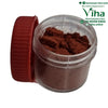 Javadhu Powder, a small clear jar of brown powder beside its ribbed red cap