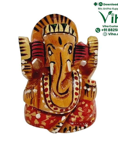 Decorated wooden Ganesha, hand-painted face with large ears and a centrally curved trunk over a red patterned base
