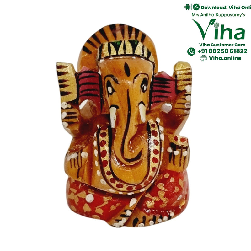 Decorated wooden Ganesha, hand-painted face with large ears and a centrally curved trunk over a red patterned base
