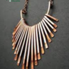 Metal Necklace Premium Quality, a copper-toned necklace with a fan-shaped pendant made of many thin, parallel metallic rods hanging from a chain