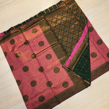 Soft Silk Saree With Blouse, folded pink fabric featuring large black round motifs and gold-toned patterns with dark green sections
