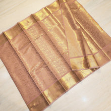Designer Silk Saree With Blouse, folded pink and shiny gold-toned fabric featuring intricate floral and geometric woven patterns