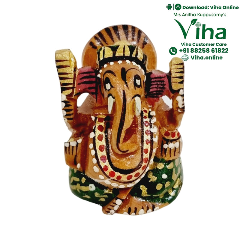 Decorated wooden Ganesha, hand-painted face with large ears and a downward curved trunk against a painted arch
