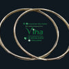 Impon Bangles, two thin glossy gold-toned metal bangles overlapping on a dark background