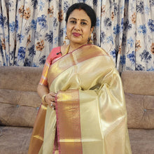 Premium Katan Silk Saree With Blouse - VIHA : 0044, a woman wearing a shiny gold-toned saree with a pink border and gold-toned jewelry