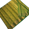 Semi Soft Silk Saree With Blouse, folded green fabric with shiny gold-toned borders and woven circular medallion patterns