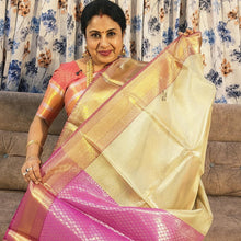 Premium Katan Silk Saree With Blouse - VIHA : 0044, a woman wearing a pink blouse and holding a gold-toned-and-pink patterned fabric