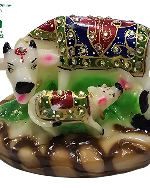 Cow and calf, painted white figures with jewelled blankets set with sparkling stones on a scallop-shaped base