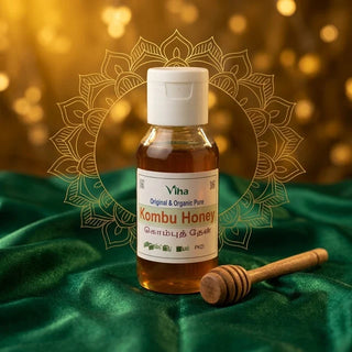 Bottle of Viha Organic Kombu Honey (kombu then) with a wooden honey dipper on green velvet