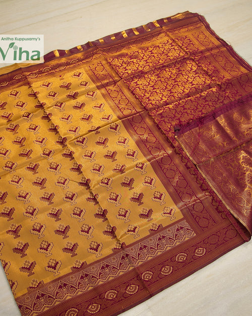 Soft Silk Saree With Blouse, a folded yellow-brown saree featuring a maroon and gold-toned patterned border and pallu