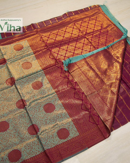Soft Silk Saree With Blouse, folded teal, magenta, and gold-toned patterned fabric with intricate woven details