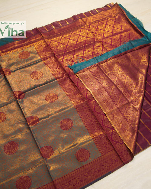 Soft Silk Saree With Blouse, folded fabric featuring a green and magenta surface with gold-toned patterned borders and circular motifs