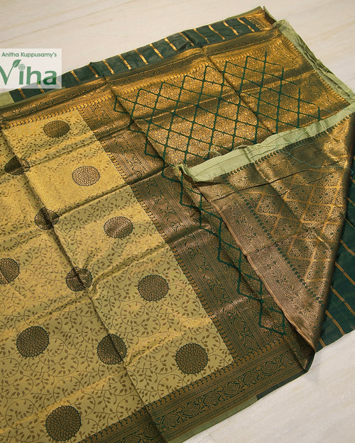 Soft Silk Saree With Blouse, folded green fabric featuring gold-toned patterned sections and borders