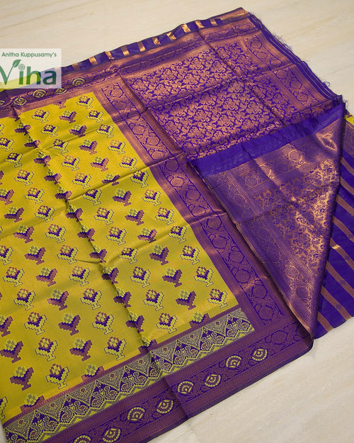 Soft Silk Saree With Blouse, a folded yellow and purple textile featuring gold-toned woven patterns with repeating geometric motifs