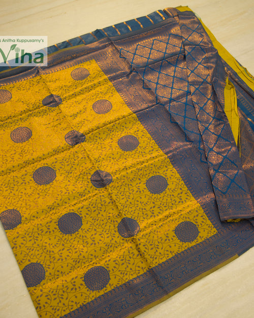 Soft Silk Saree With Blouse, a folded yellow textile featuring grey-blue circular patterns and a complex border design