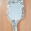 Elegant Framed Handheld Rectangle Shape Mirror, a silver-toned handheld mirror with ornate floral embossed frame surface resting on wooden surface