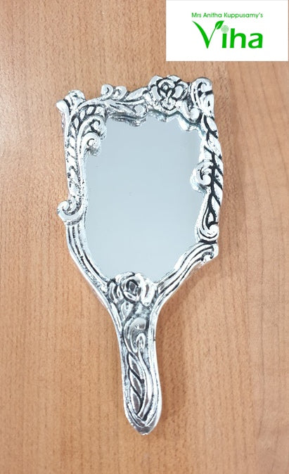 Elegant Framed Handheld Rectangle Shape Mirror, a silver-toned handheld mirror with ornate floral embossed frame surface resting on wooden surface