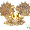 Double Peacock (Showpiece), two gold-toned peacocks with spread, textured tail feathers set with red and green stones, facing each other on an oval base