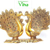 Double Peacock (Showpiece), two gold-toned peacocks face each other with fan-like tail feathers inset with small red, green, and blue stones on a base