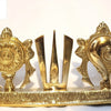 Sangu Chakra Namam Stand, three shiny gold-toned metallic emblems on a rectangular base, featuring a circular motif, a trident-like symbol, and a conch shape