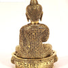 Brass Buddha - Statue, a gold-toned figurine seated on a circular base featuring intricate patterns on its back and hair, viewed from behind