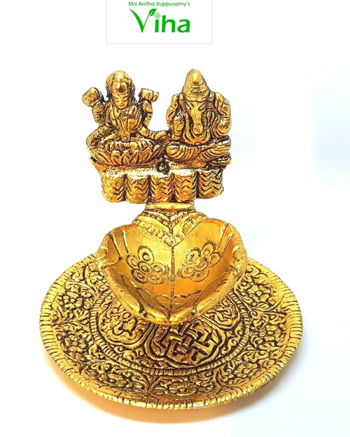 Lakshmi Ganesha lamp, both deities seated above a heart-shaped oil bowl on a round engraved plate