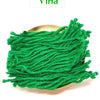 A coiled bundle of bright green cotton lamp wick in a gold-toned dish