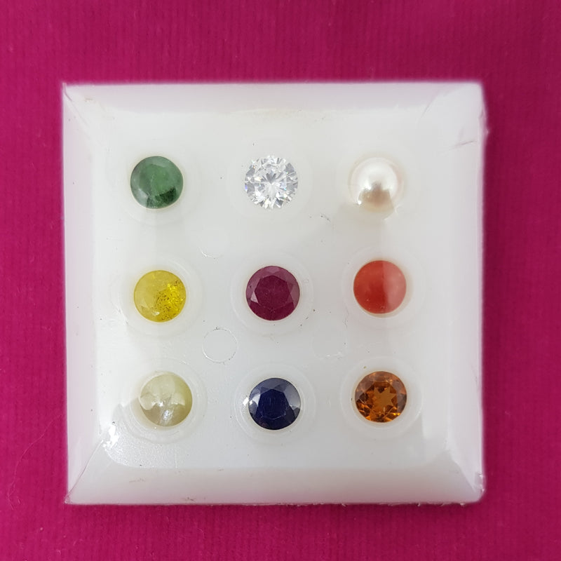 Navaratna Stones With Zircon Stone, nine small stones in a white box with round compartments