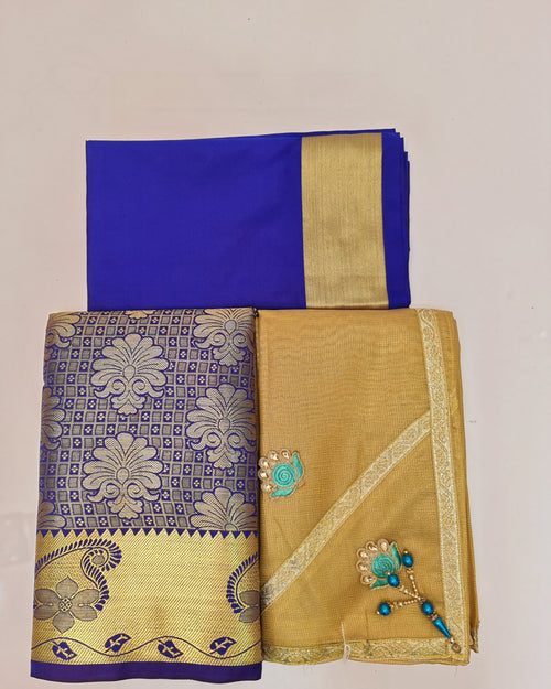 Apoorva Silk Half Saree Set, folded royal blue and gold-toned fabric pieces with floral patterns, ornate borders, and two decorative turquoise motifs