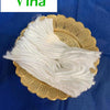 A bundle of white cotton lamp wick on a gold paper doily against a blue cloth