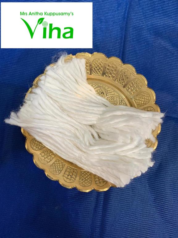 A bundle of white cotton lamp wick on a gold paper doily against a blue cloth