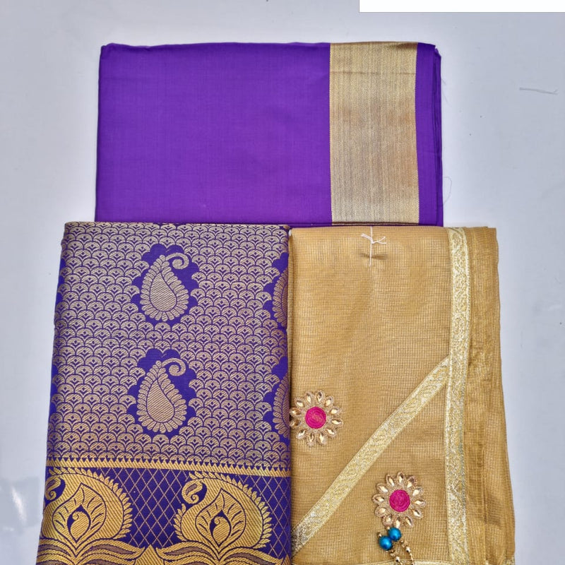 Apoorva Silk Half Saree Set, a purple fabric with gold-toned borders alongside a gold-toned piece featuring two flower-like patches and blue beads