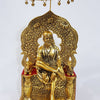 Sai Baba, seated figure on a throne beneath an arched backslab and a fringed hanging canopy