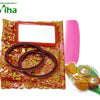 Thamboolam Bag Set, two maroon bangles, a rectangular mirror, a pink comb, and yellow threads lie on a red patterned pouch and a green leaf shape