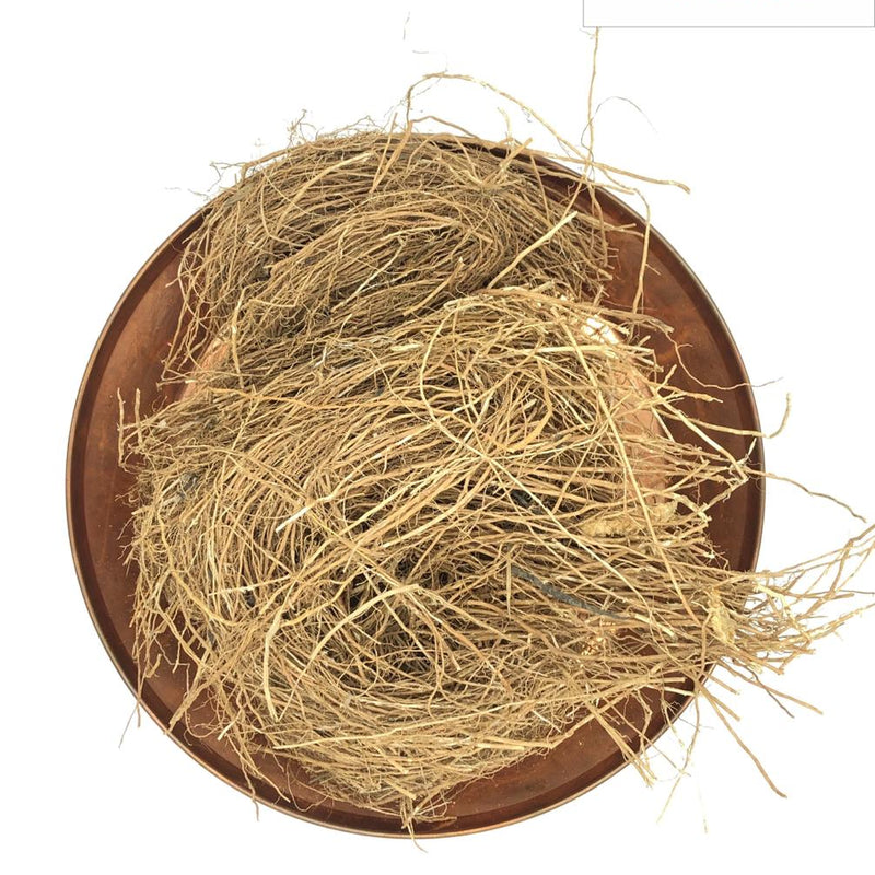 Vetiver, round copper-colored metal tray filled with a tangled cluster of light brown fibrous roots